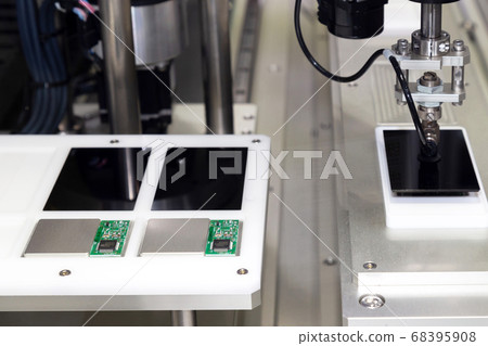 automatic robot arm with vacuum sucker working in the production line and assembling smartphone screens in the new innovative and high technology smartphone factory. . 68395908