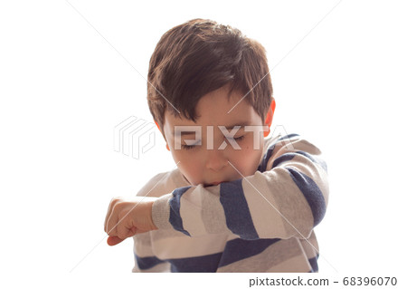 A boy sneezes or coughs into his elbow on white background. 68396070