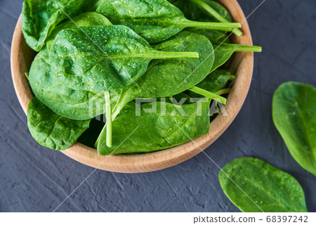 Fresh spinach leaves in wooden bowl on dark 68397242