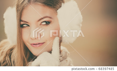 Portrait of suspicious pretty woman in earmuffs Portrait of suspicious pretty woman in earmuffs 68397485