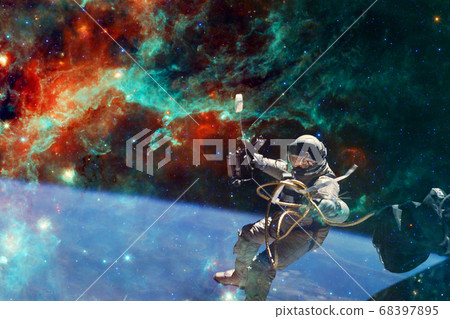Astronaut. Nebula, cluster of stars. Elements of this image furnished by NASA 68397895