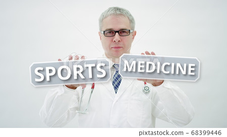 Doctor holds SPORTS MEDICINE words in his hands Doctor holds SPORTS MEDICINE words in his hands 68399446