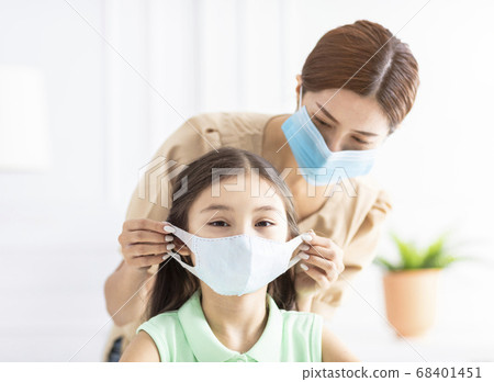 mother help her daughter wearing healthy face mask 68401451