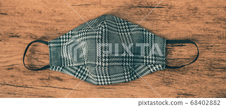 Fashion fabric face mask in plaid houndstooh pattern. Stylish masks for outfits during autumn winter with wooden panoramic banner background Fashion fabric face mask in plaid houndstooh pattern. Stylish masks for outfits during autumn winter with wooden panoramic banner background 68402882