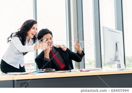 Two happy business people celebrate at office 68405994