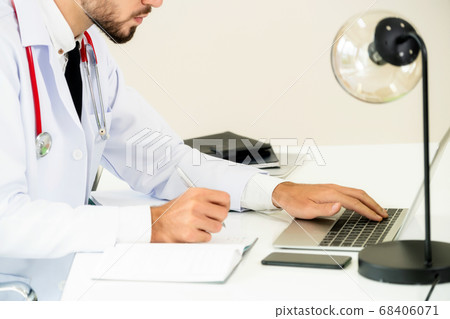 Doctor working on laptop computer hospital. 68406071