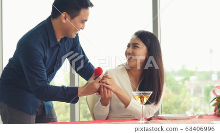 Romantic couple giving gift to lover at restaurant 68406996