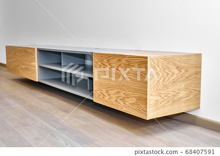 Floating media cabinet in contemporary living room. Wall mounted wooden cabinet Floating media cabinet in contemporary living room. Wall mounted wooden cabinet 68407591