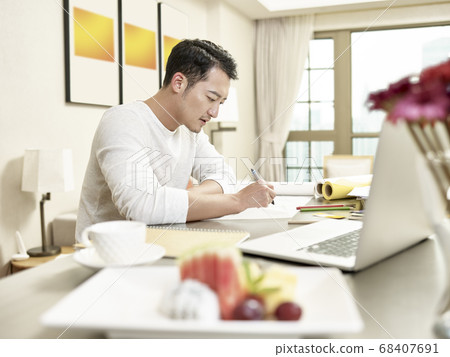 young asian man design professional sitting at kitchen counter working from home 68407691