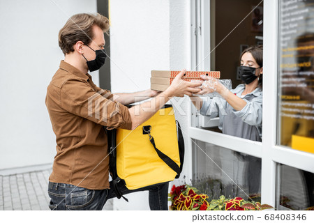Courier taking an order for delivering from the shop window 68408346