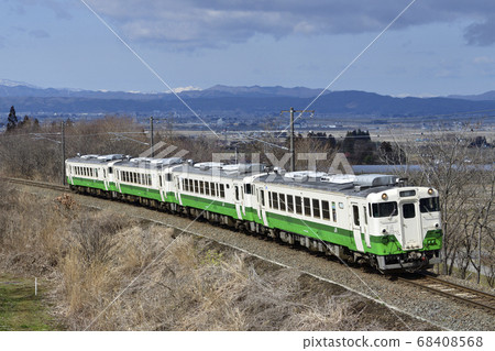 A JNR type diesel car running on the Banetsu west line with the Aizu basin in the background (Tohoku region headquarters color) 68408568