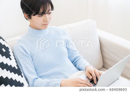 觀看一台便攜式計算機的婦女在屋子裡 觀看一台便攜式計算機的婦女在屋子裡 68409693
