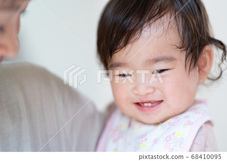 Up of smiling baby and mom being hugged Up of smiling baby and mom being hugged 68410095