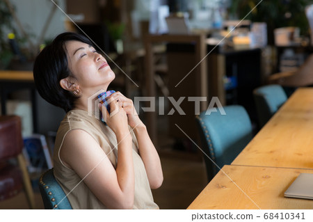 Woman in her 40s wiping her sweat off with a handkerchief 68410341