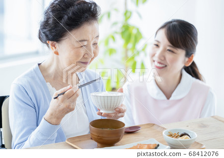Caregiver image Caregiver assisting with senior woman eating 68412076