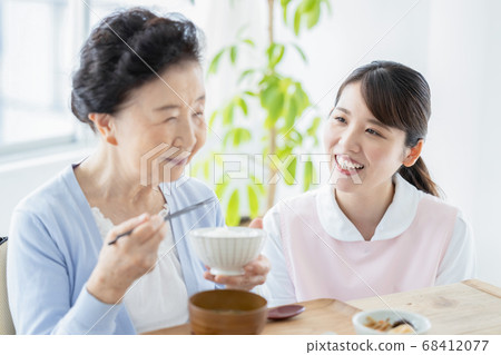 Caregiver image Caregiver assisting with senior woman eating 68412077