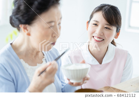 Caregiver image Caregiver assisting with senior woman eating Caregiver image Caregiver assisting with senior woman eating 68412112