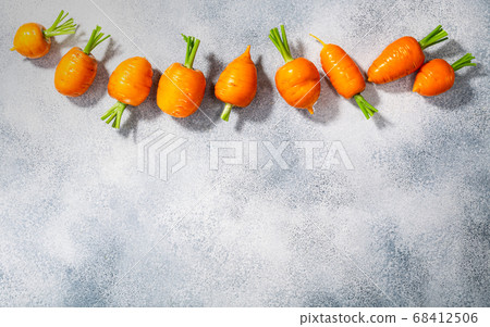 Short Rondo carrots on grey textured background 68412506