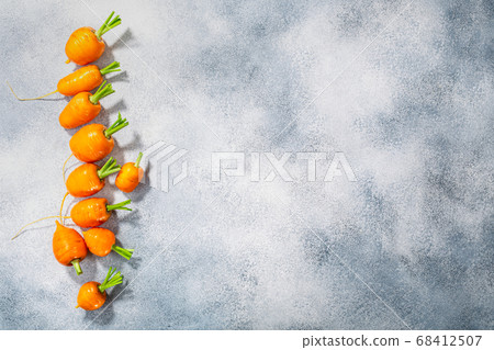 Short Rondo carrots on grey textured background 68412507