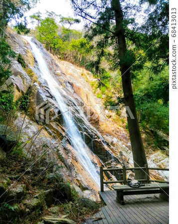 Bench overlooking the waterfall and the waterfall Bench overlooking the waterfall and the waterfall 68413013