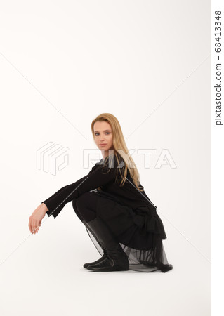 Blonde lady sitting on her haunches in profile on Blonde lady sitting on her haunches in profile on 68413348