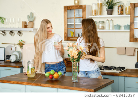 Two young pretty women drinking lemonade and Two young pretty women drinking lemonade and 68413357