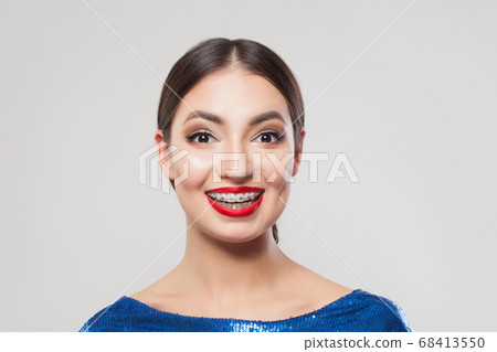 Happy excited woman with braces on teeth smiling Happy excited woman with braces on teeth smiling 68413550