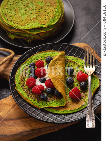 Spinach crepes with cheese , raspberries and blueberries. Spinach crepes with cheese , raspberries and blueberries. 68416116