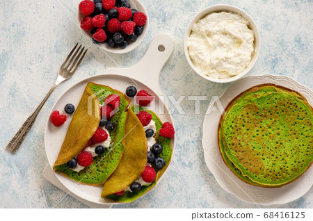Spinach crepes with cheese , raspberries and blueberries. Spinach crepes with cheese , raspberries and blueberries. 68416125