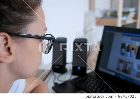 Portrait of woman student learning language on computer sitting at home in dark. Portrait of woman student learning language on computer sitting at home in dark. 68417023