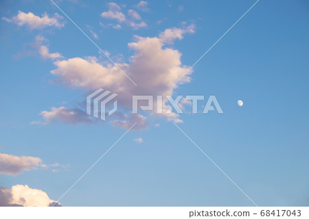 Heart-shaped clouds and small moon at dusk 68417043