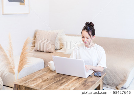 A woman using a personal computer at home 68417646