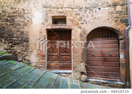 wooden doors in a rustic wall in Montalcino 68418724