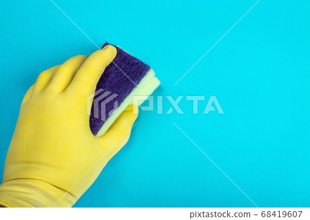 hand in a yellow rubber glove holds a sponge for washing and cleaning hand in a yellow rubber glove holds a sponge for washing and cleaning 68419607