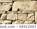 Ancient petroglyphs on the stone walls of an old house 68422003