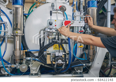 Competent mechanic doing checkup of pressure in unit 68422148