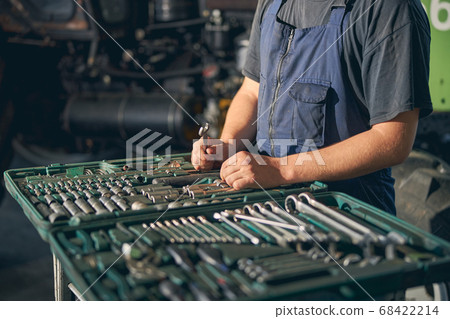 Close up of mechanic standing near case with tools 68422214
