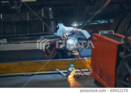 Close up of serious man welding metal parts Close up of serious man welding metal parts 68422270