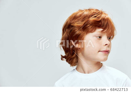 Red-haired boy face close-up head turned on the side close-up gray background Red-haired boy face close-up head turned on the side close-up gray background 68422713