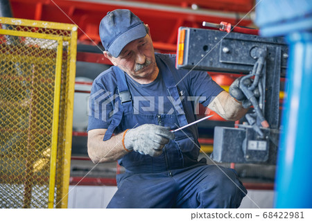 Concentrated repairman working in hangar with instruments Concentrated repairman working in hangar with instruments 68422981