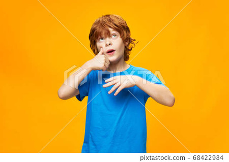 Cute red-haired child touching face with finger Cute red-haired child touching face with finger 68422984