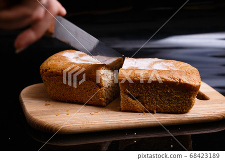 Homemade gray bread on a black background. Photo in section. Homemade gray bread on a black background. Photo in section. 68423189