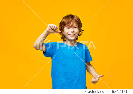 Cheerful boy with red hair gestures with his hands positive gesture smile blue t-shirt studio close-up Copy Space. Cheerful boy with red hair gestures with his hands positive gesture smile blue t-shirt studio close-up Copy Space. 68423711