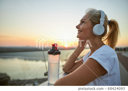 Joyous lady with a ponytail listening to music Joyous lady with a ponytail listening to music 68424093