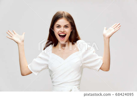 woman smiling broadly gesturing with hands white dress cropped view studio gray background woman smiling broadly gesturing with hands white dress cropped view studio gray background 68424095