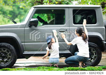 Mother and daughter washing cars Mother and daughter washing cars 68424924