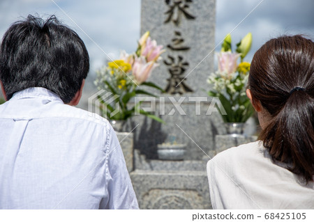 Young men and women visiting the grave 68425105