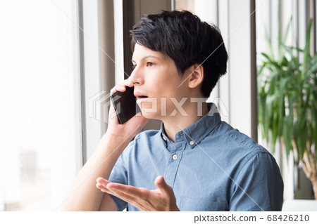一個年輕人談話在智能手機 68426210