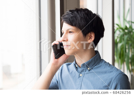 A young man talking on a smartphone 68426256