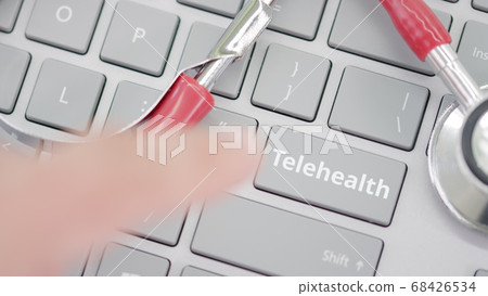 Pressing TELEHEALTH key on a keyboard near stethoscope 68426534